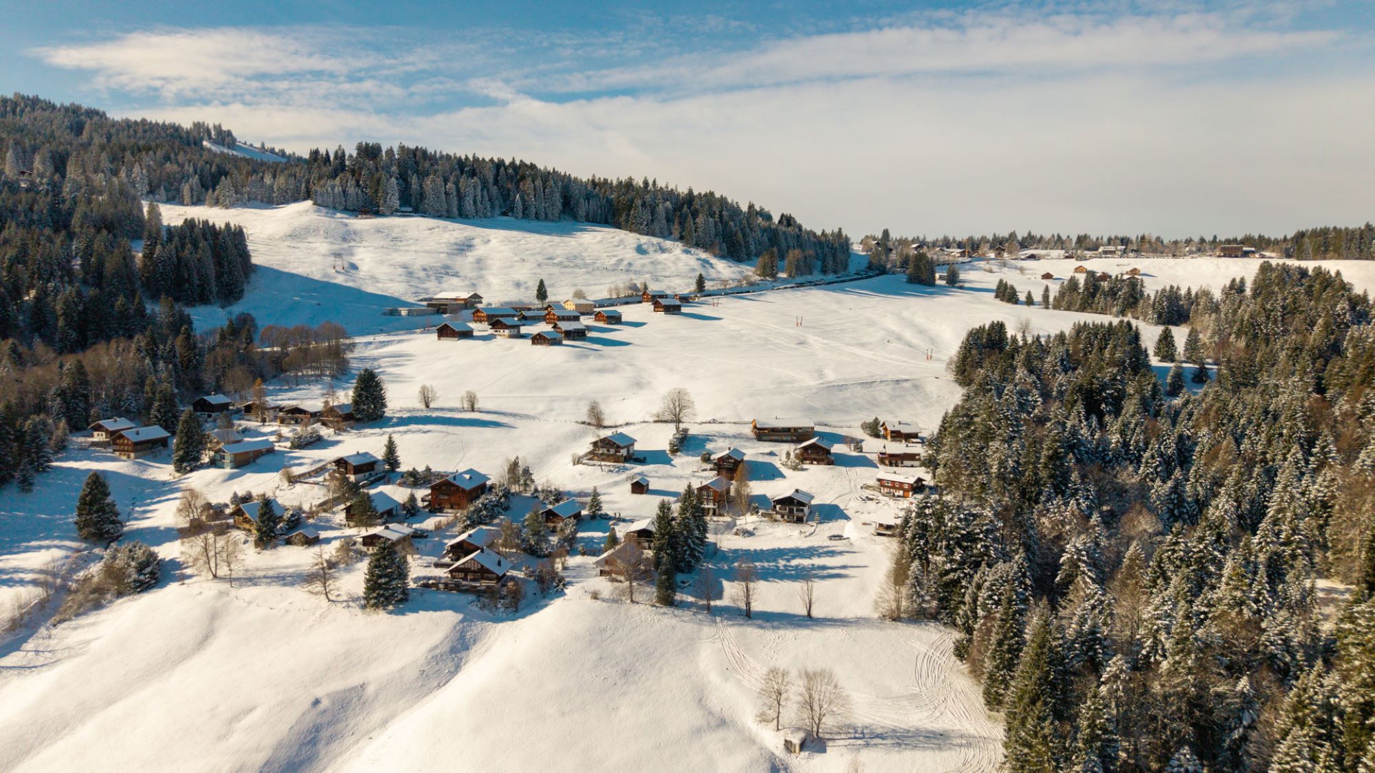 Das Bild zeigt eine Luftaufnahme der Region Eixer in Schwarzenberg. Im Hintergrund ist der Skilift Weisstanne des Skigebiet Bödele zu sehen, der zu Fuß nur einige Minuten vom Ferienhaus entfernt ist.